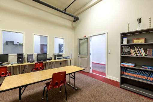 A room with a table, chairs, and a bookshelf at Nantucket Lofts Apartments, Kinston, NC