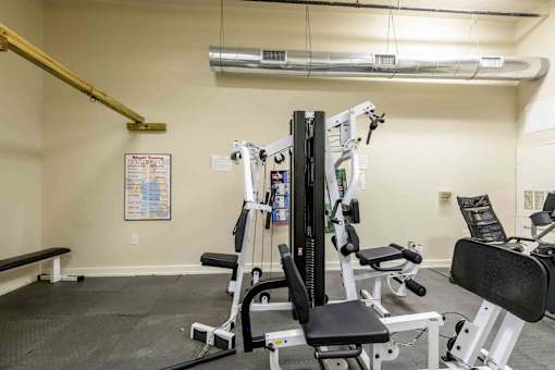 A gym with a variety of equipment including a leg press machine at Nantucket Lofts Apartments, Kinston, NC