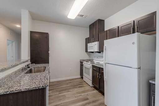 A kitchen with a white refrigerator, white oven, and white microwave. at Ogeechee Place, Savannah, 31405