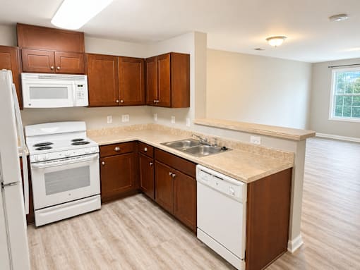 A kitchen with white appliances and wooden cabinets.