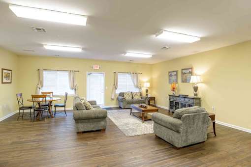 A living room with a grey sofa, a wooden table and a fireplace at Robinson Park Apartments, Harrisonburg