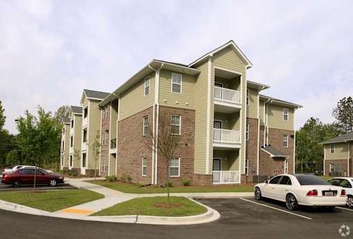 A large apartment building with a parking lot in front.at Summerville Garden, Summerville South Carolina
