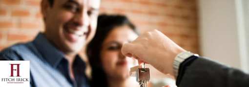 A person is handing over a key to another person.