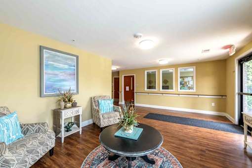 A living room with a sofa, a table, and a painting on the wall. at The Grande at Granite Falls LLC Apartments, Rolesville, North Carolina