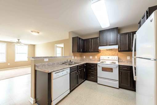 A kitchen with a white refrigerator, a white stove, and a white dishwasher at The Grande at Granite Falls LLC Apartments, North Carolina, 27571