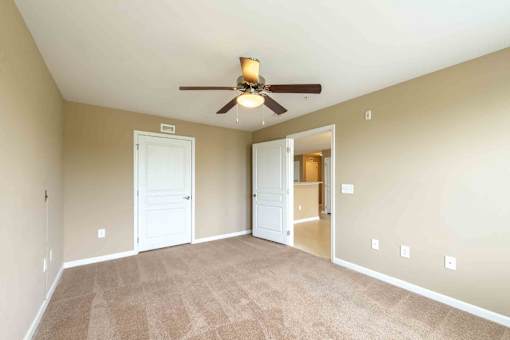 A room with a ceiling fan and carpeted floor. at The Grande at Granite Falls LLC Apartments, Rolesville, NC