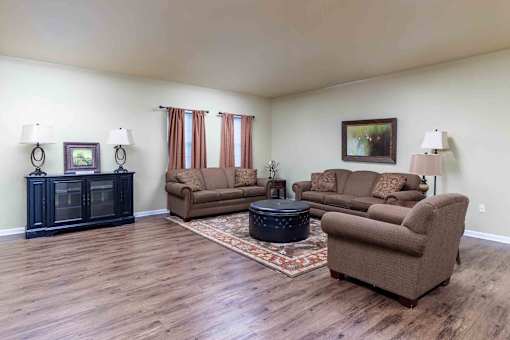 A living room with brown furniture and a rug. at The Shire Apartments, Virginia, 23325