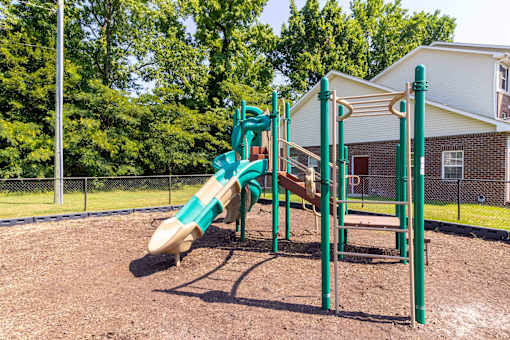 A playground with a green slide and a brown sandbox. at The Shire Apartments, Chesapeake, VA, 23325
