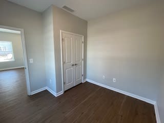 an empty living room with wooden floors and a door at Braddock Terrace, Aldie, VA 20105