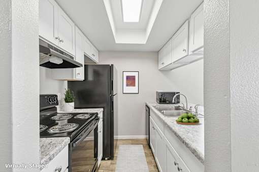 A kitchen with a black stove top oven and a black refrigerator.