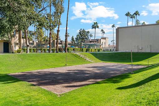 A large open area with a pathway and a green lawn.