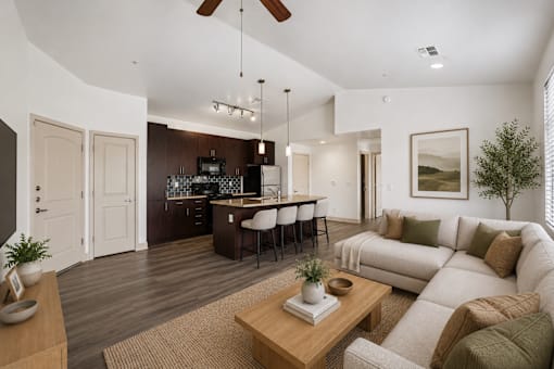 A modern living room with a kitchen in the background.