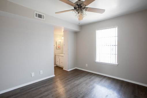 A room with a ceiling fan and a window.