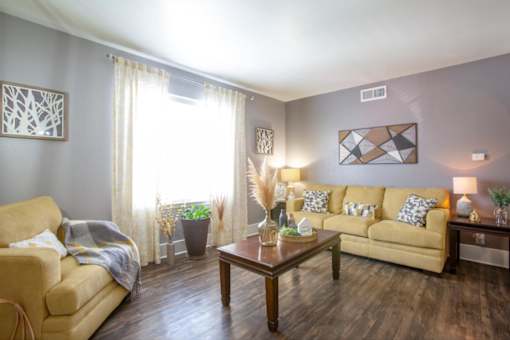A living room with a tan couch, a coffee table, and a lamp.