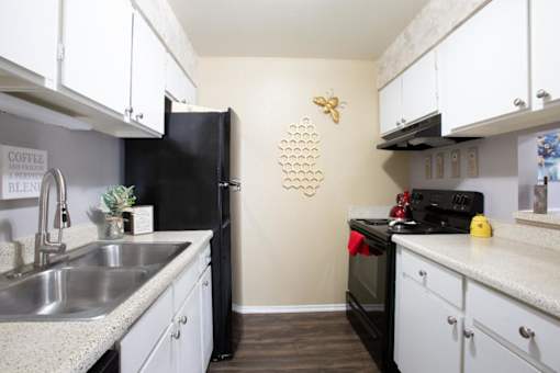 A kitchen with black appliances and white cabinets.