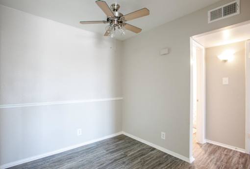 A room with a ceiling fan and light fixture.