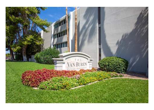 The Van Buren building is surrounded by a well-manicured lawn and a flower bed.