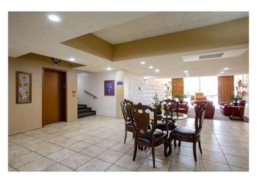 A dining room with a table set for four.