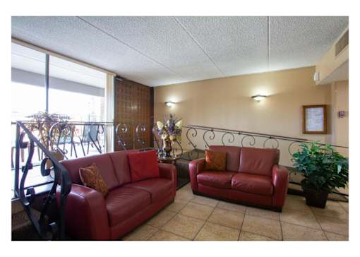 Two red couches in a room with a window.