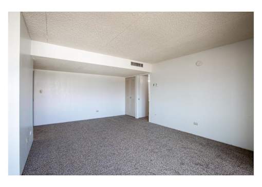 A room with carpeted floor and white walls.
