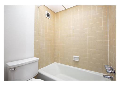 A white toilet next to a bathtub in a bathroom.