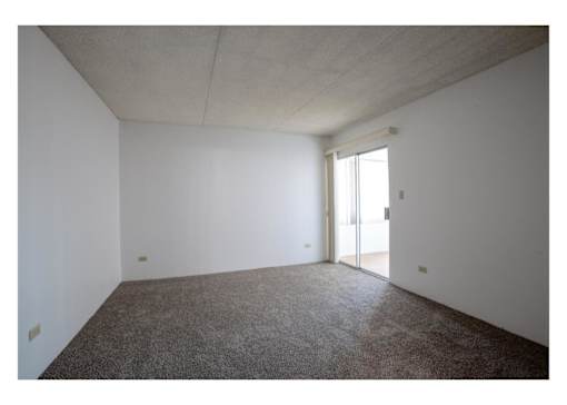 A room with a carpeted floor and a sliding glass door.