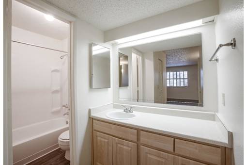 A bathroom with a white sink and a white tub.