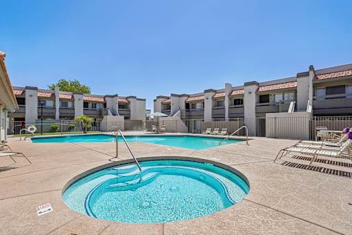 A swimming pool in a residential area with a clear blue sky.