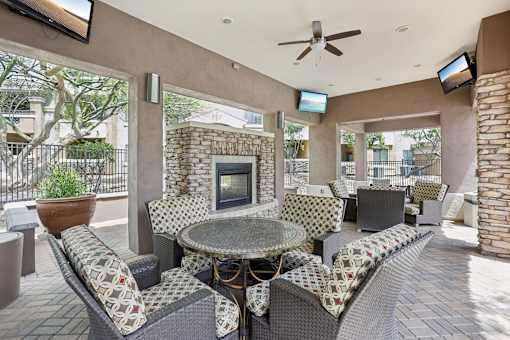 A patio with a table, chairs, and a fireplace.