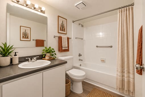 A bathroom with a white toilet, sink, and shower.