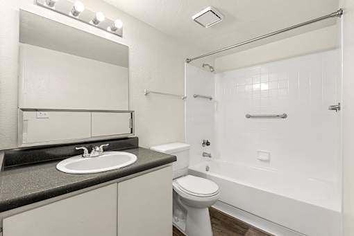 A white bathroom with a sink, toilet, and bathtub.