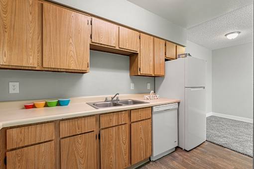 A kitchen with wooden cabinets and a white refrigerator.