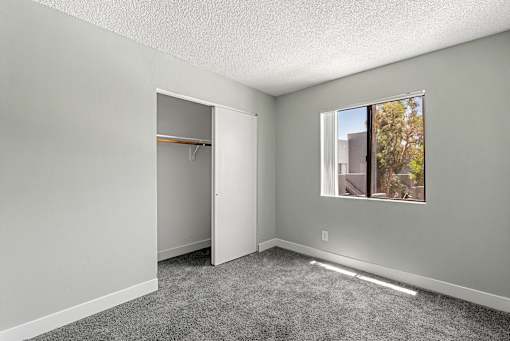 A room with a grey carpet and a white door.