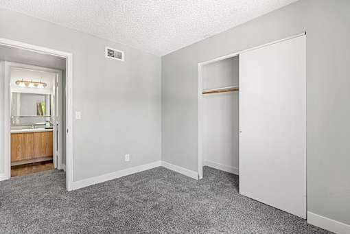 A room with a grey carpet and white walls.