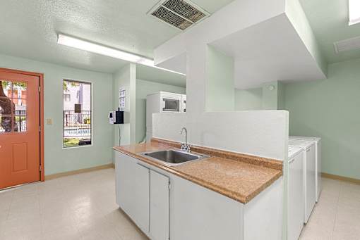 A kitchen with white cabinets and a wooden countertop.