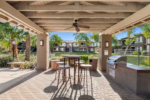 A patio with a table and chairs under a roof.