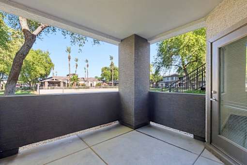 A patio with a view of a tree and houses.