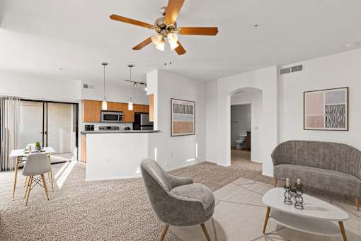 A living room with a grey chair and a white coffee table.