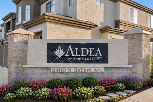 A stone sign with the name Aldea at Estrella Falls on it.