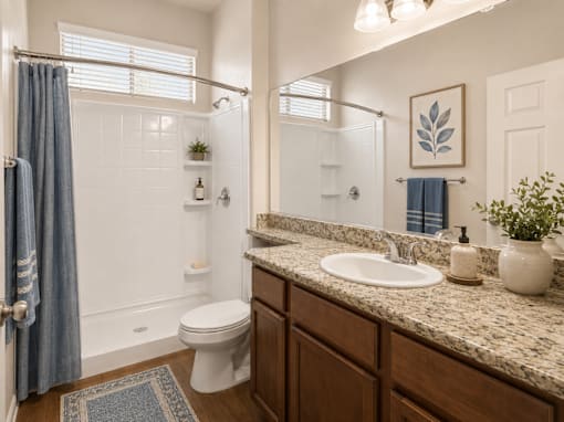 A bathroom with a white toilet, a sink, and a shower.