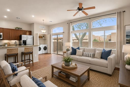 A well-lit living room with a ceiling fan and a large window.