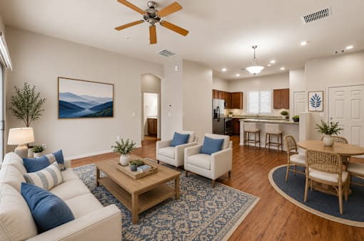 A living room with a white couch and a painting of a mountain scene on the wall.