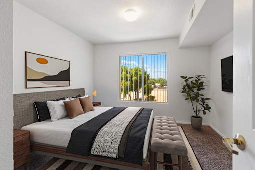 A bedroom with a large bed and a painting on the wall.