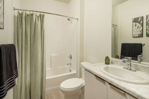 A bathroom with a toilet, sink, and shower curtain.