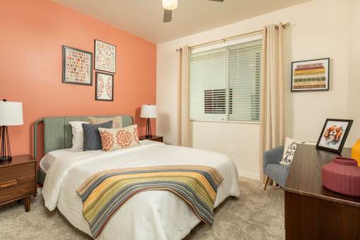 A bedroom with a bed, nightstand, and chair.