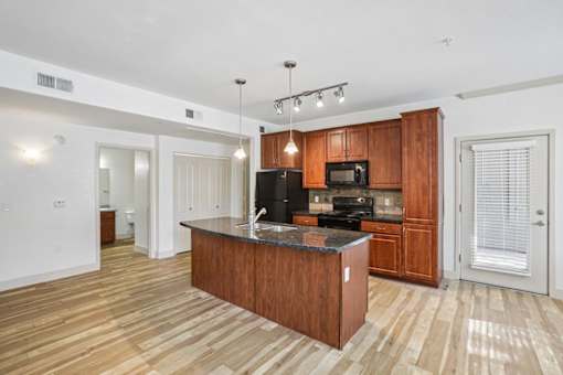 A kitchen with wooden cabinets and a black stove top oven.