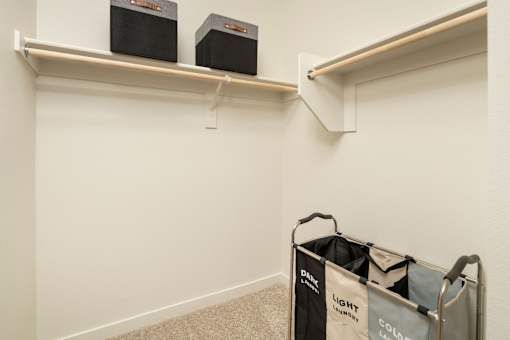 A room with two shelves and a laundry basket.