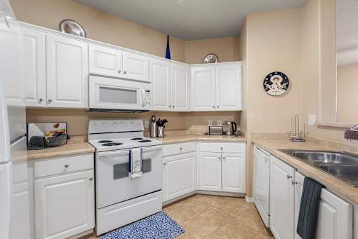 A kitchen with white cabinets and appliances.