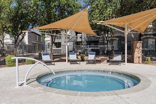A small pool surrounded by chairs and umbrellas.