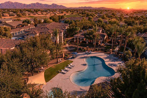 A sunset view of a residential area with a swimming pool.